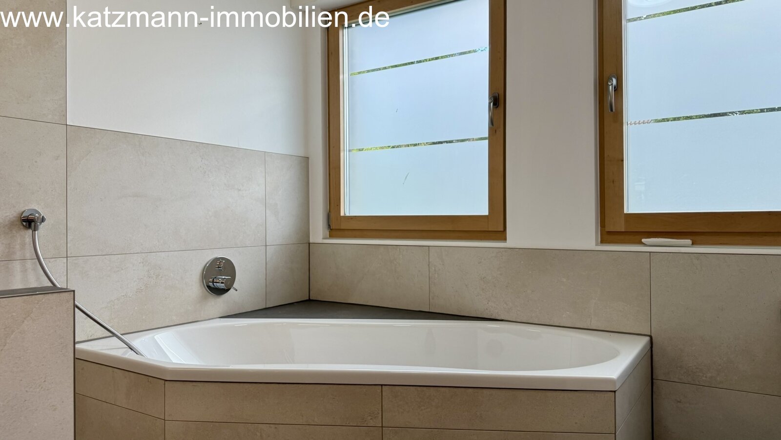 Wellness oasis with natural light: inviting corner bathtub with elegant natural stone design