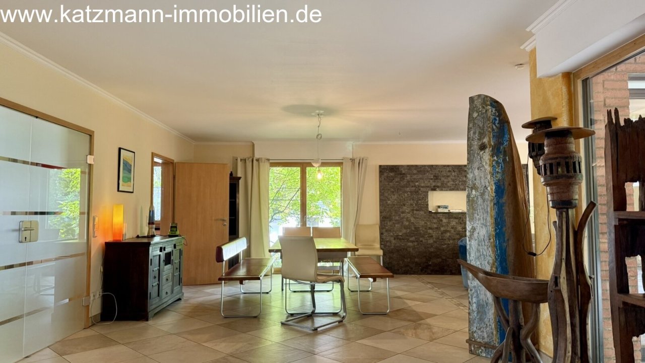 Bright living and dining area with a harmonious natural stone accent wall and elegant layout