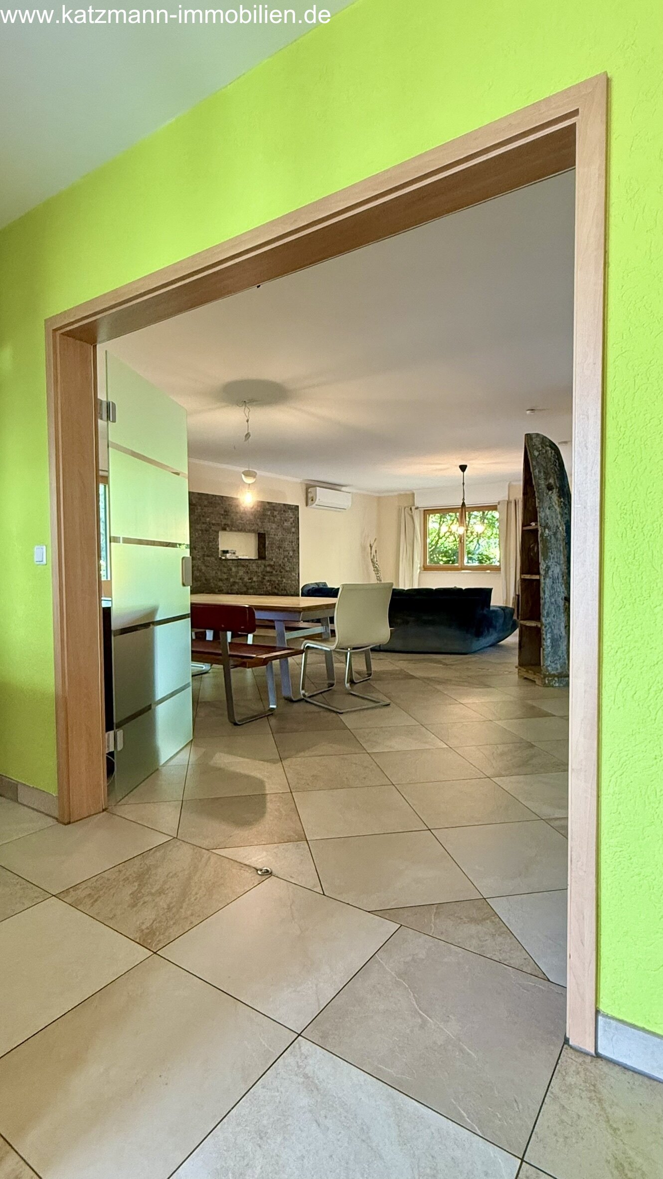 Bright living-dining area with an elegant natural stone accent wall and spacious layout