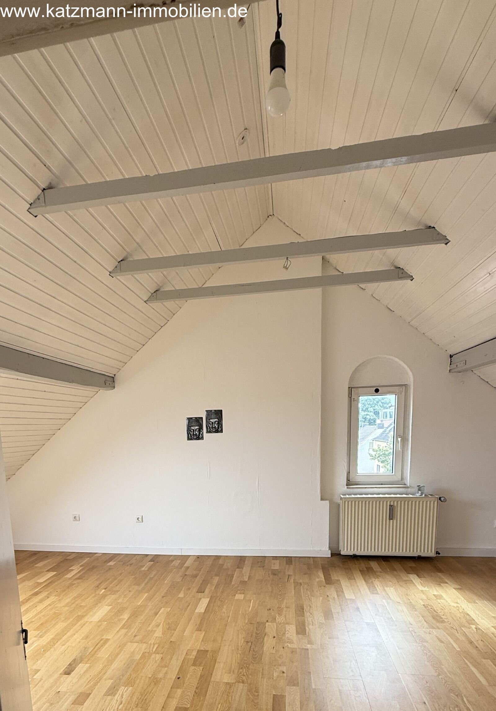 Bright attic room with high-quality wooden flooring and charming exposed beam design