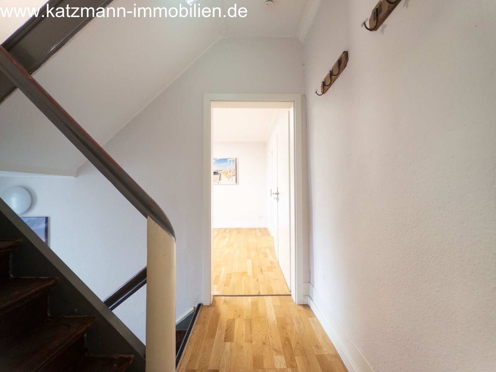 Brightly lit corridor with high-quality wooden flooring - connecting floors with elegant design