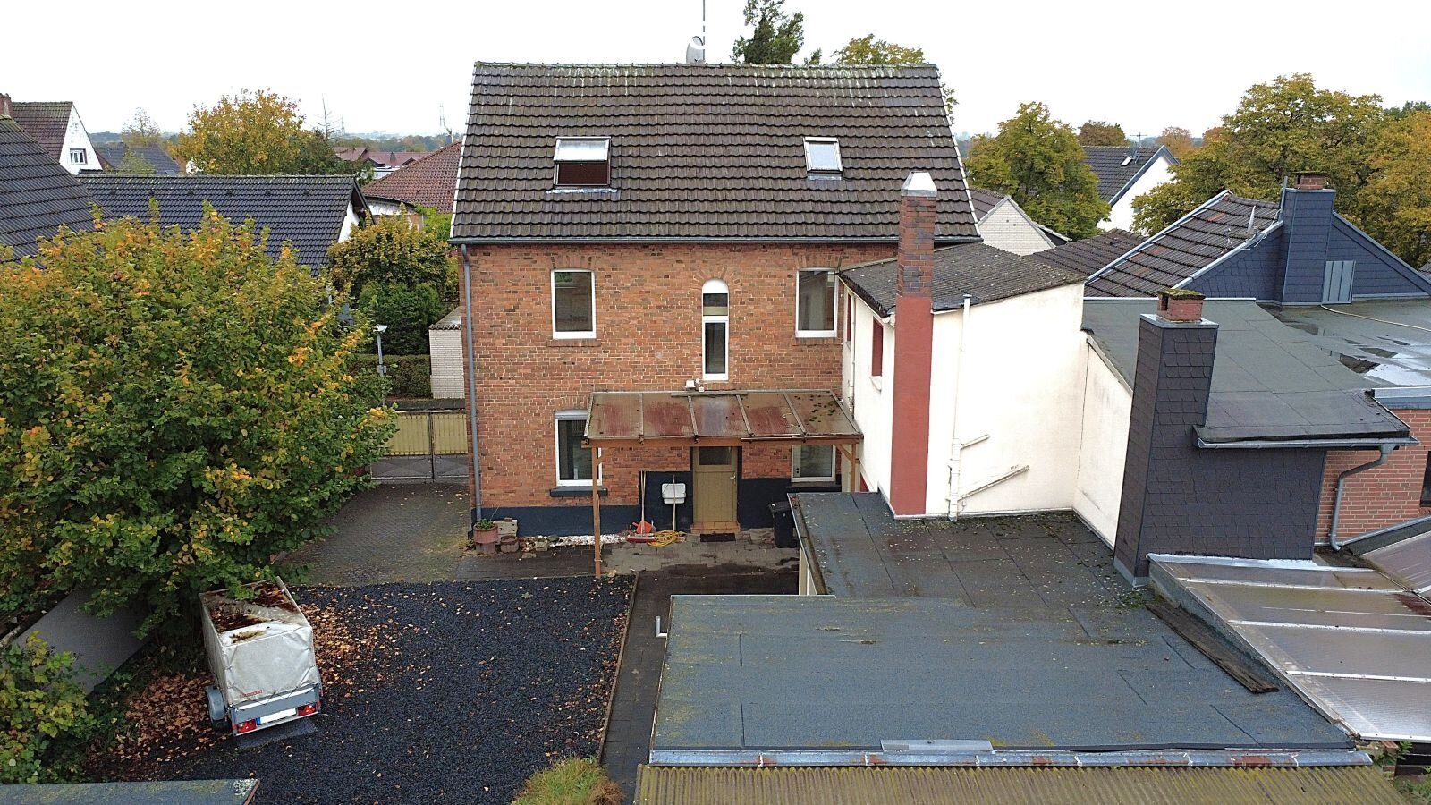 Development potential: Charming brick house with attic option and flexible outbuildings!