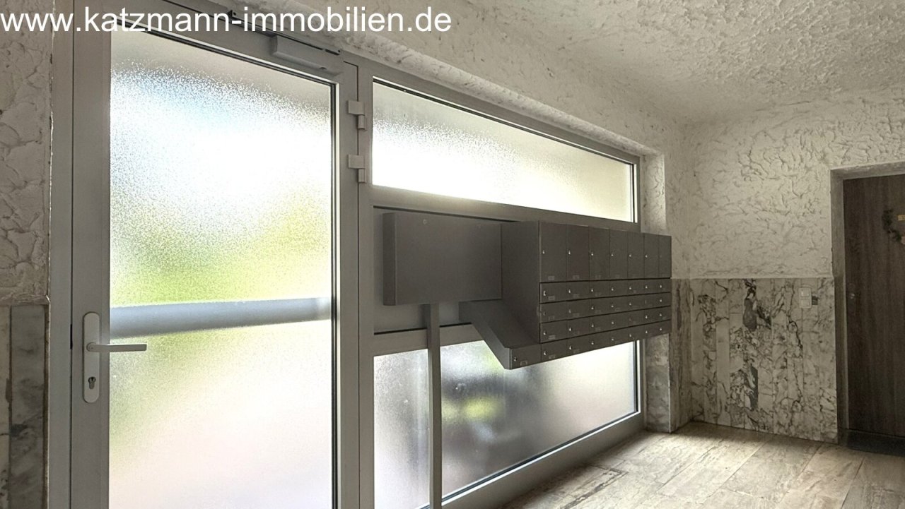 Área de buzones iluminada con luz natural y fachada moderna de ventanas - ¡Bienvenido a casa!