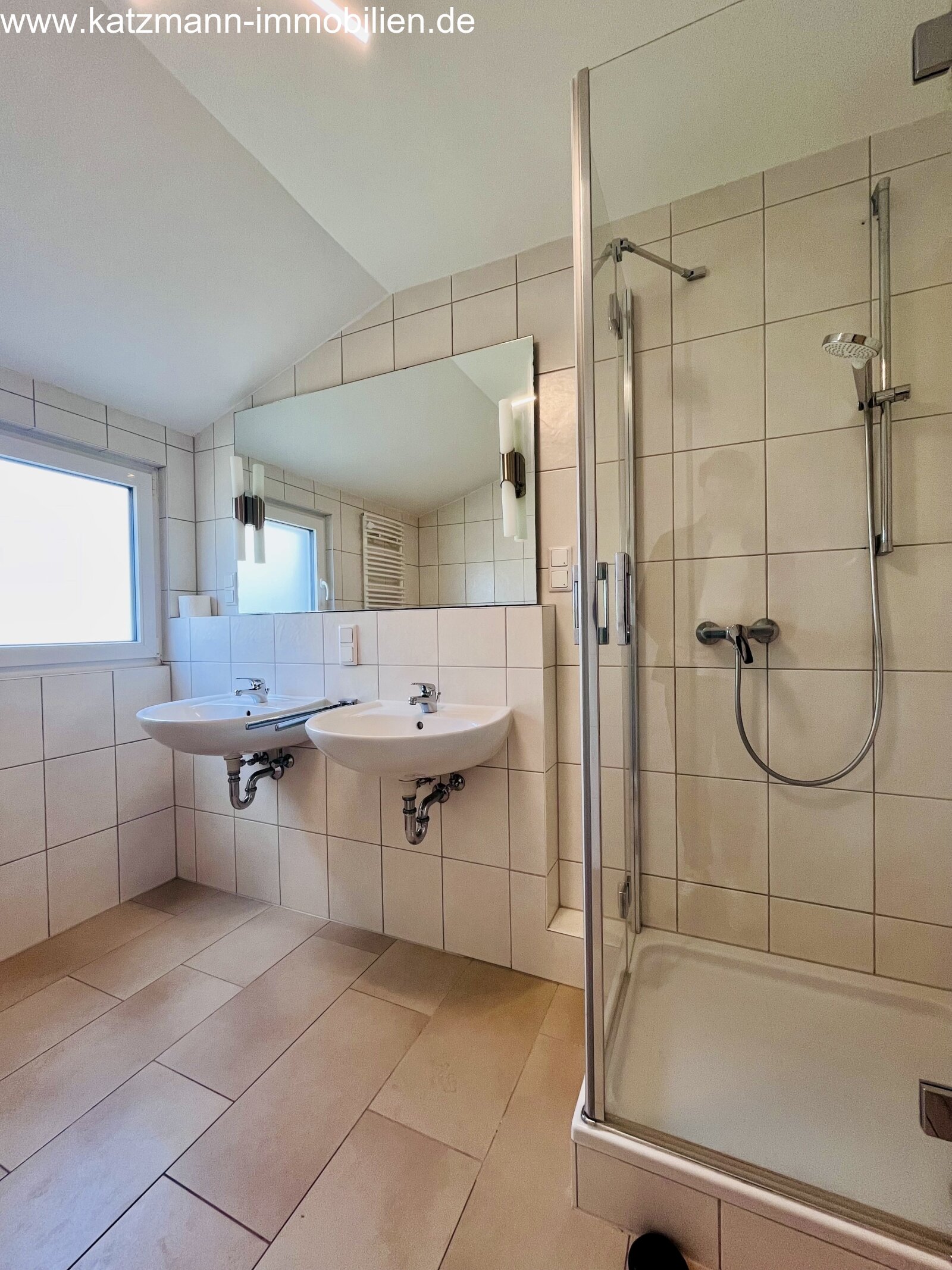 Salle de bain moderne avec double lavabo et grande douche en verre - ambiance bien-être lumineuse dans un espace réduit !