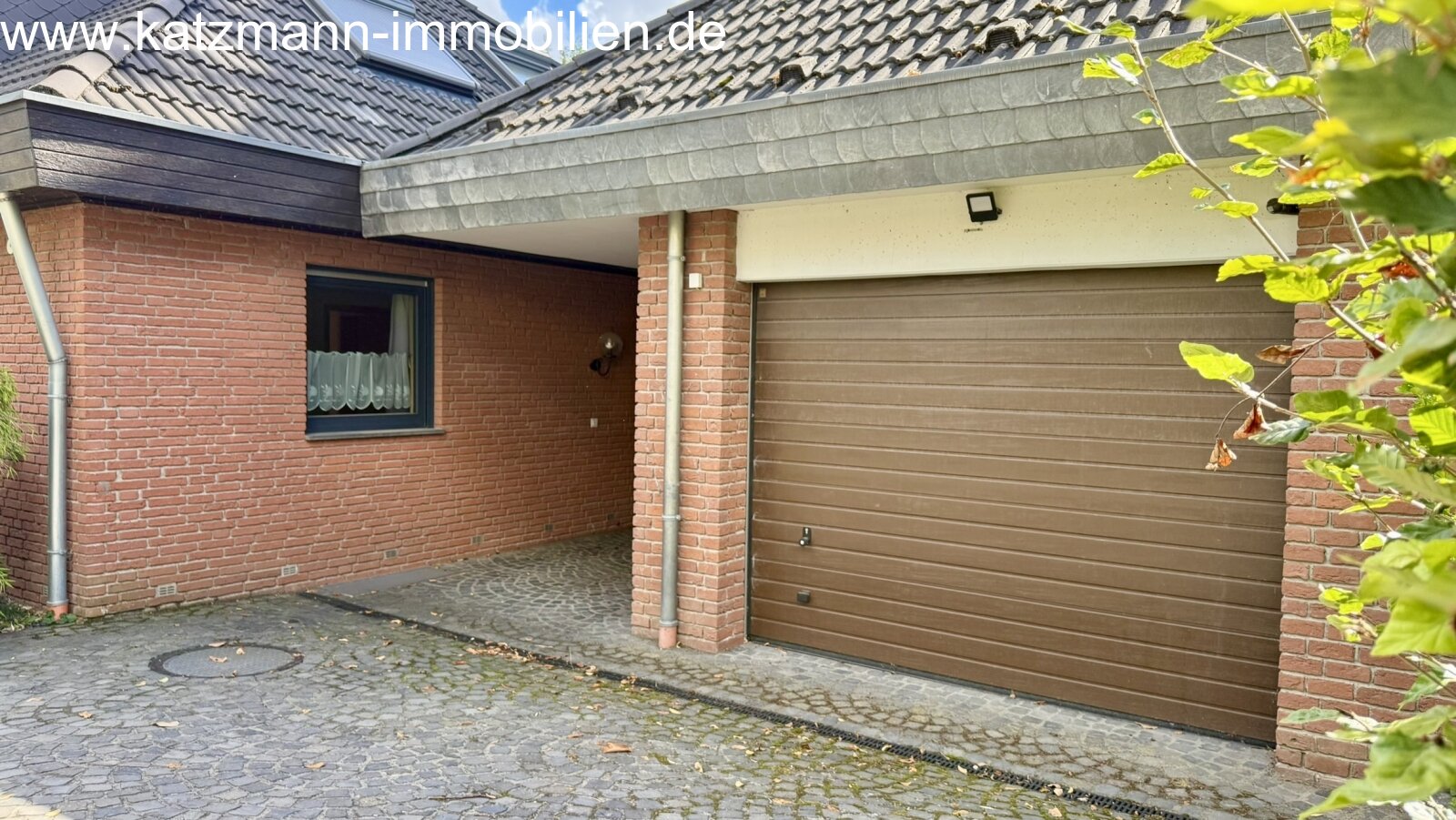 Pas de modifications dans le texte !Un chez-soi confortable avec une entrée couverte et un garage à porte roulante électrique - une architecture pratique avec du charme !