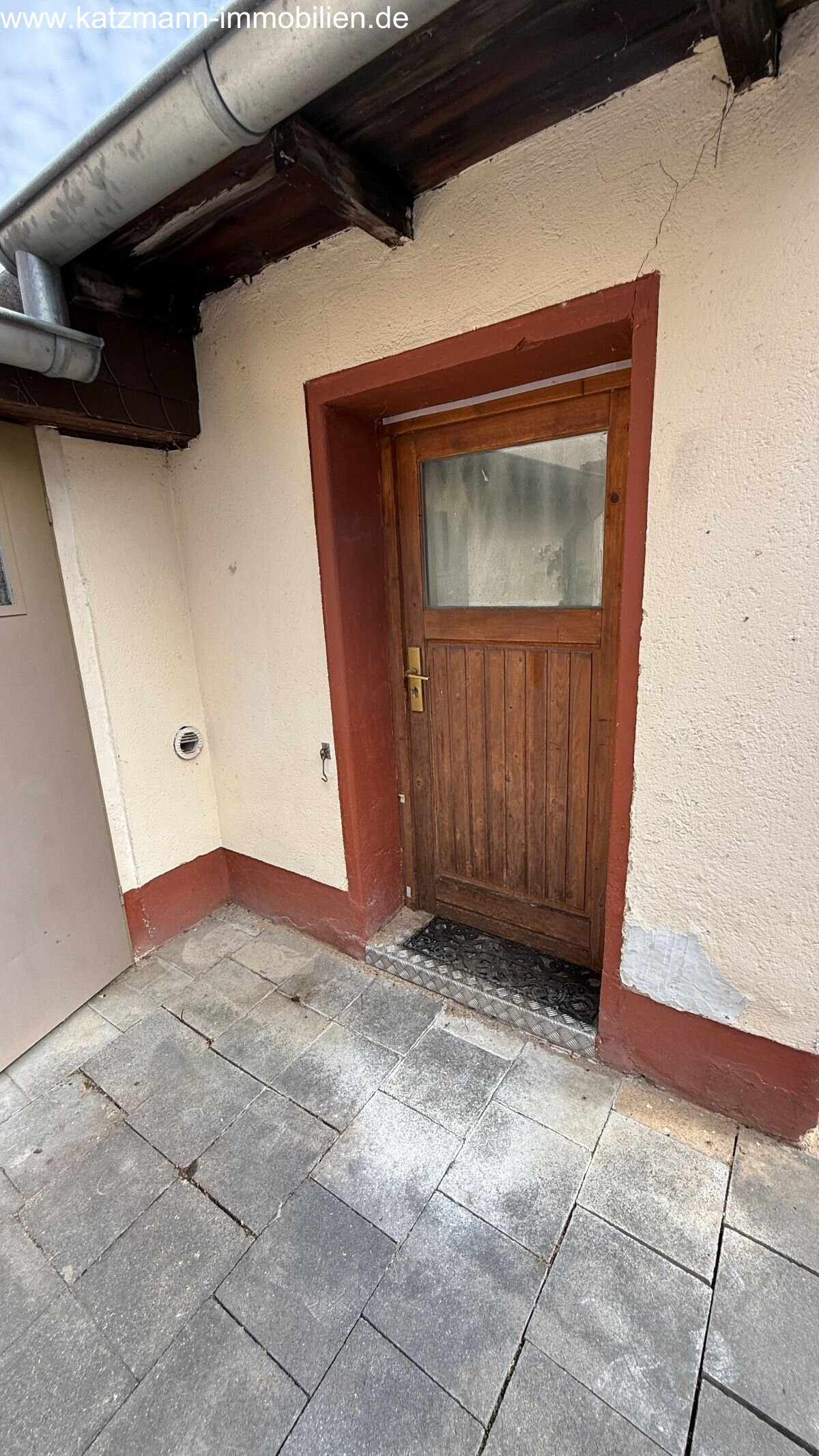 Charme inclus: Entrée rustique avec porte en bois et pavage en pierre naturelle - votre porte vers l'authenticité!