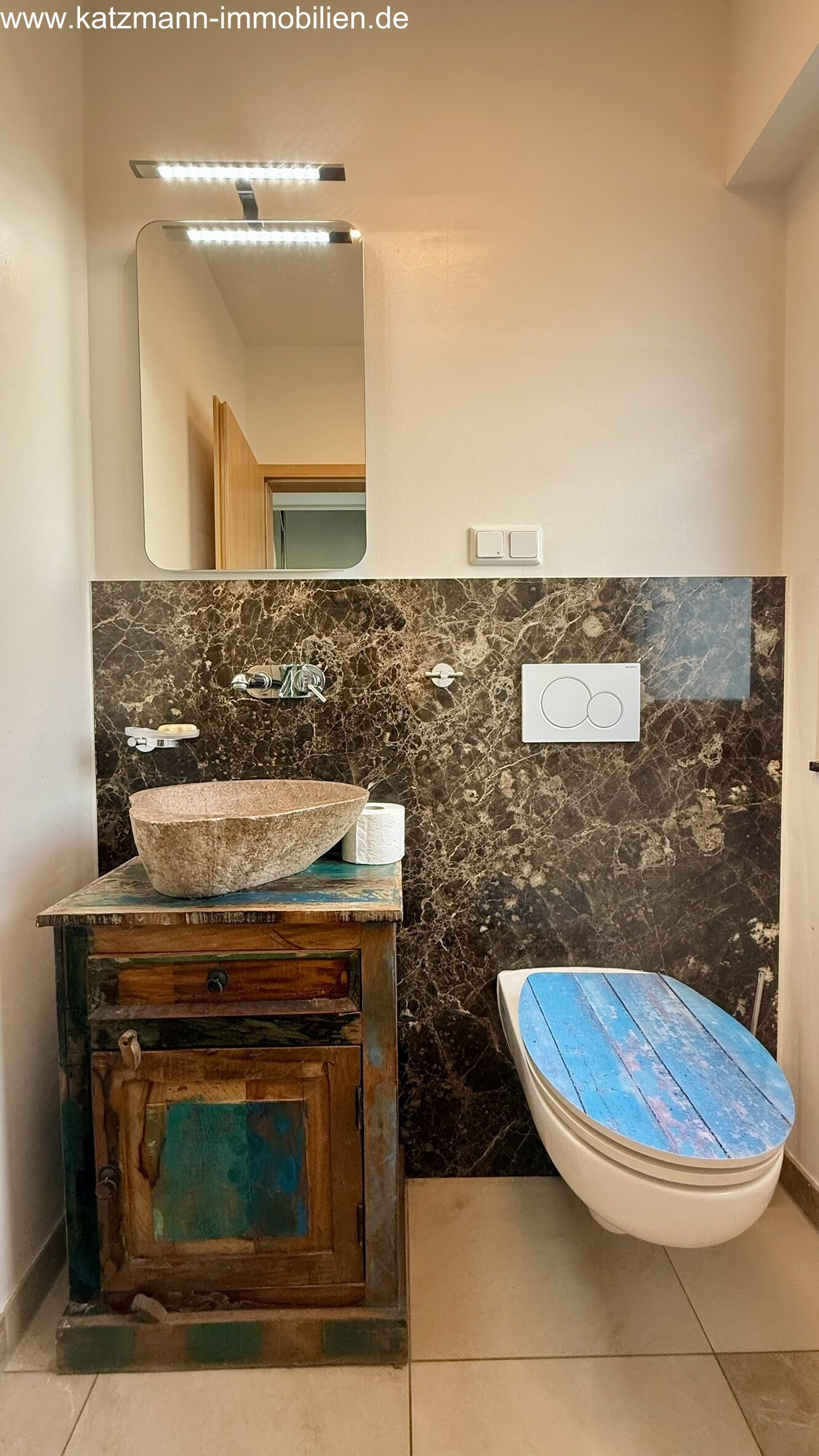 Bagno ospiti esclusivo con accenti in pietra naturale e lavabo di design - un'atmosfera di benessere unica in uno spazio ridotto!