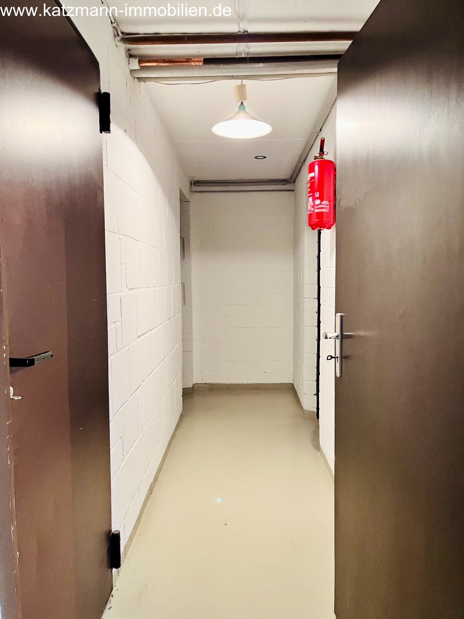 Sicurezza inclusa: corridoio interrato funzionale con attrezzature antincendio e illuminazione ottimale